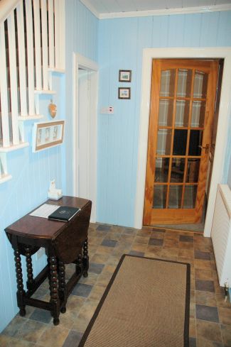 The front door of Bruaich Cottage in Lochcarron opens into the hallway from which there are doors to the kitchen/dining room, the living room and the bathroom. The hall, stairs and landing are pine-clad and tastefully decorated.